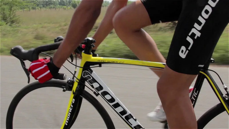 Frame from a Montra Road product film: a cyclist in Montra kit riding a yellow road bike, panned so the roadside behind blurs with the speed
