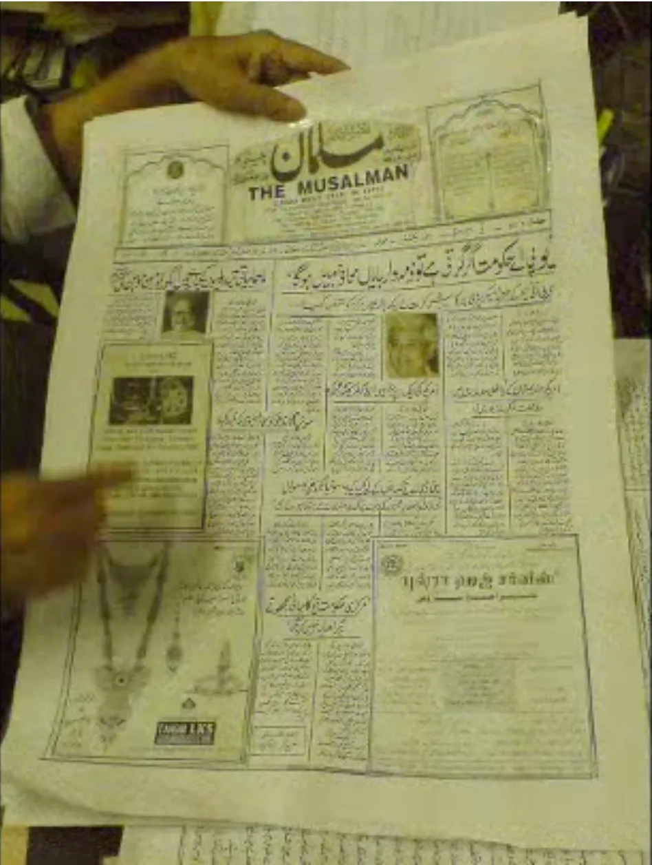 The front page of The Musalman, written entirely by hand in Urdu calligraphy, held up in the newspaper's office